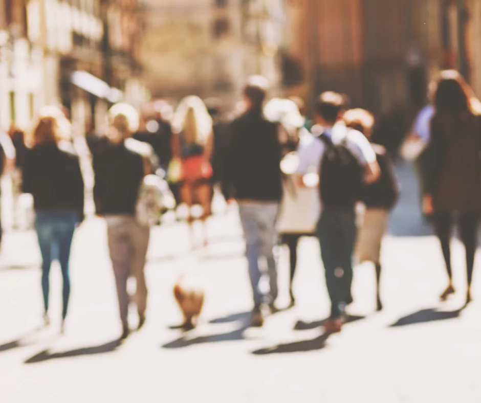 Rozmyte zdjęcie grupy osób idącej chodnikiem