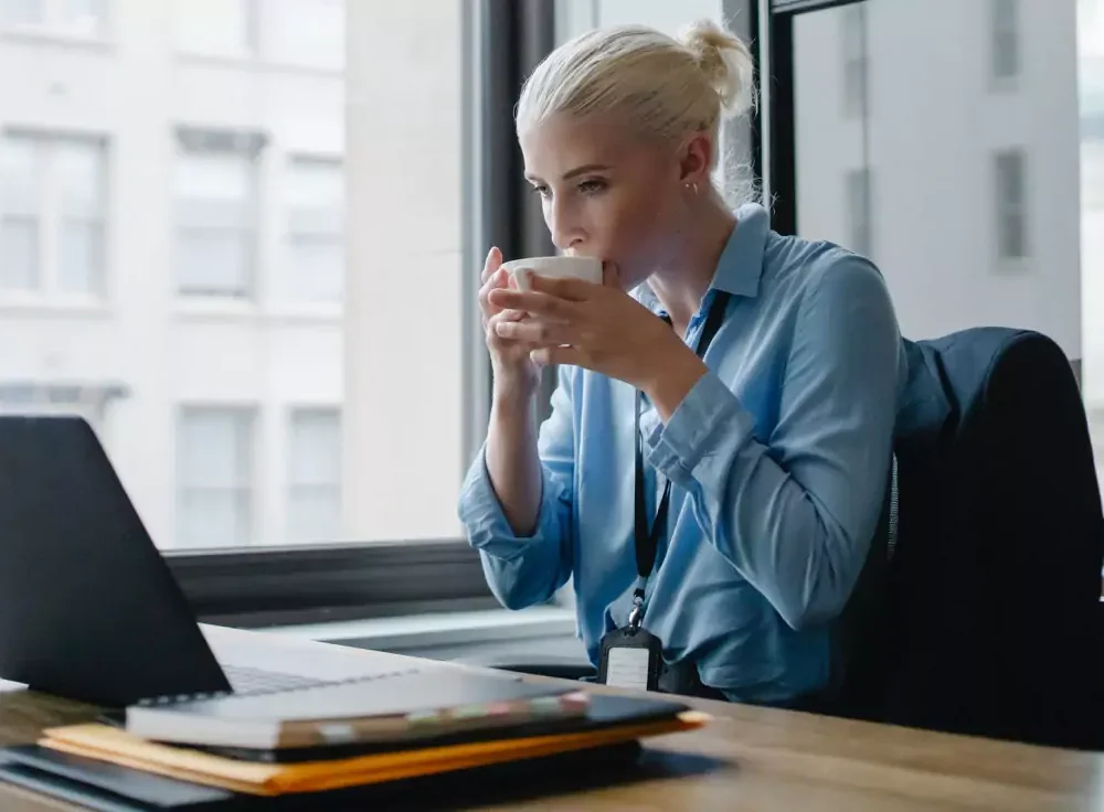 Pani z filiżanką przy laptopie
